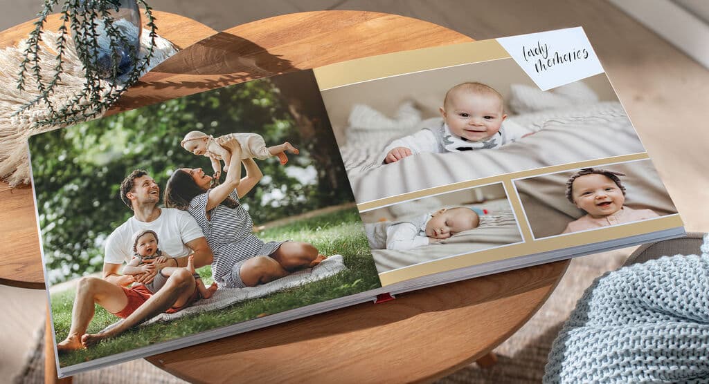 Открытая фотокнига на столе: семья с малышом + кадры ребёнка
